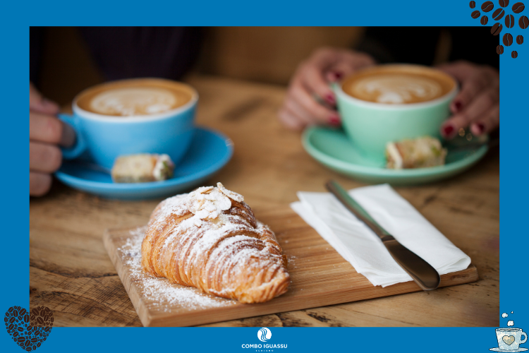 Duas pessoas tomando um café com um croissant em frente | Cafés em Foz do Iguaçu? Nós te indicamos alguns!